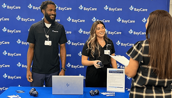 Two BayCare team members standing behind a table at a recruiting event.