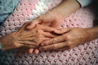 Picture of elderly woman and younger woman holding hands