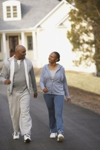 Photo of two older folks walking through a neighborhood