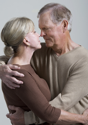 Older man and older woman hugging.