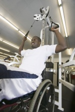 Photo of young man in wheelchair lifting weights