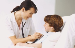 Nurse listening to boy's chest with stethoscope