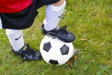 Child's foot on top of a soccer ball