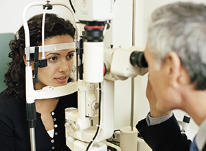 Healthcare provider examining woman's eye.