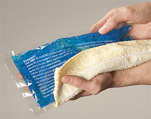 Hand holding gel ice pack in towel.