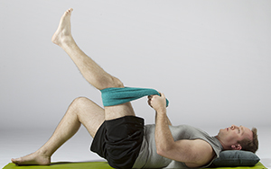 Man doing hamstring stretch exercise on floor.