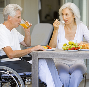 Woman and man in wheelchair eating breakfast.