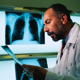 Photograph of a radiologist reading an X-ray