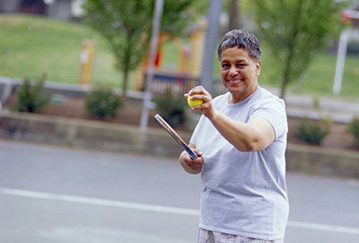 Photo of a middle aged woman getting ready to serve a tennis ball