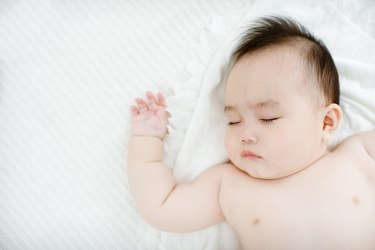 Close up view of a baby sleeping on his back.