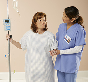 Woman walking in hospital with healthcare provider.