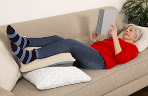 Woman lying on couch with feet raised.