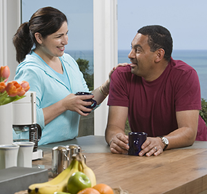 Couple talking at kitchen counter.