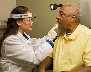 Doctor examining patient's mouth.