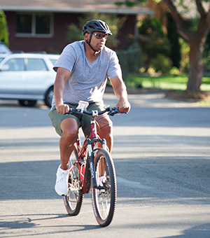 Man bicycling on neighborhood street.
