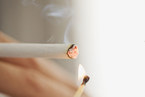 Close up of woman lighting cigarette.