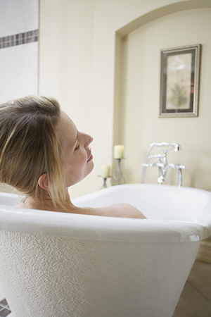 Woman relaxing in bathtub.