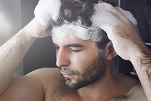 Man shampooing hair in shower.