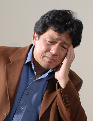 Close-up image of stressed man's face.