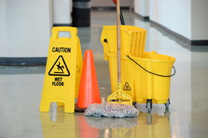 Yellow caution wet floor sign and yellow mop bucket.