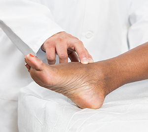 Doctor examining woman's foot.