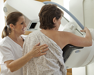 Technician helping woman during mammogram