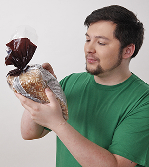 Reading food labels will help you stay away from foods with gluten. Man in grocery store reading nutrition label on package.
