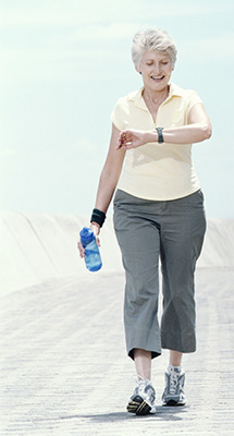 Photo of a senior woman checking the heart rate monitor on her wrist while walking