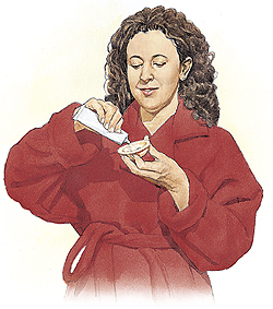 Woman filling diaphragm with spermicide.