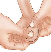 Closeup of hands checking testicle during testicular self-exam.