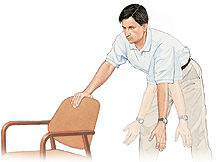Man holding onto chair and bending over at waist with one arm hanging. Ghosting shows him swinging arm back and forth from shoulder.