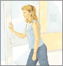 Image of woman bending knees slightly, leaning in and pushing against door