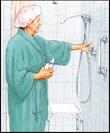 Woman in robe turning on water in shower. Shower chair is in shower stall. Grab bar and handheld showerhead are installed.
