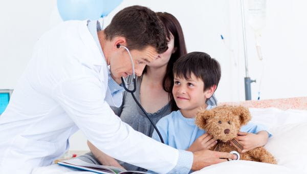 A pediatric patient being examined with their caretaker nearby