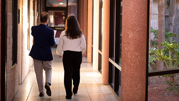 a man and woman walking down a hallway