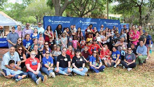 an outdoor photo of dozens of heart reunion group members