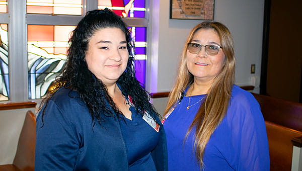 two women wearing blue smiling for a photo