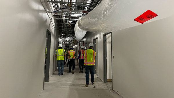 a hallway with several men in neon work jackets