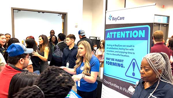 a crowd of people in front a blue screen that reads "attention"