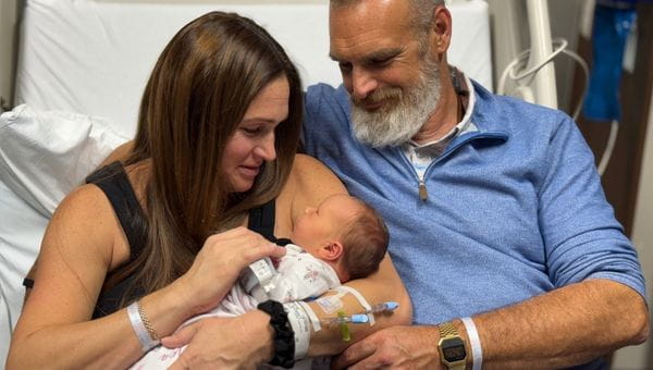 A mother and father holding their baby