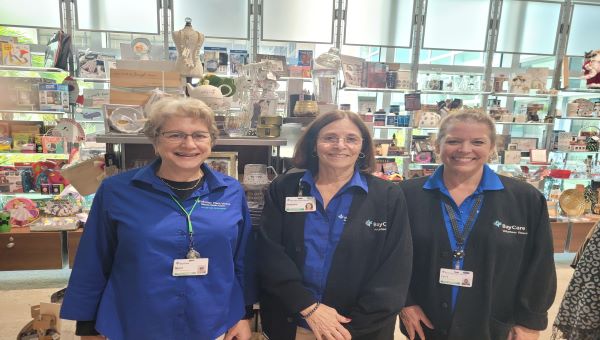 Three adult volunteers standing in the hospital gift shop.