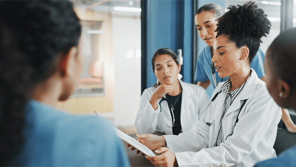 A group of doctors engaged in discussion, representing collaboration in a graduate medical program.