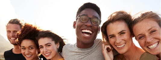 A diverse group of friends smiles for a photo.