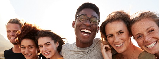 A diverse group of friends smiles for a photo.