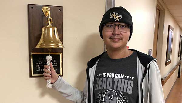 aya aceti ringing the bell to signify his cancer recovery