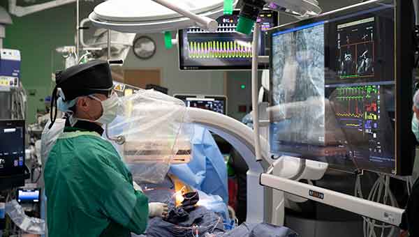 cardiac surgeon looking at monitor inside of tavr operating room