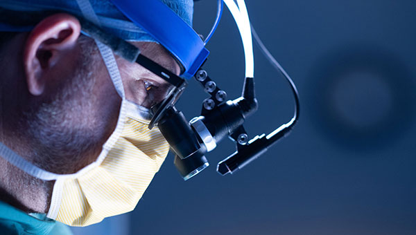 closeup photo of doctor wearing mask and scrubs preparing to operate