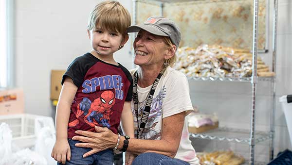 photo of woman and young boy smiling at food pantry