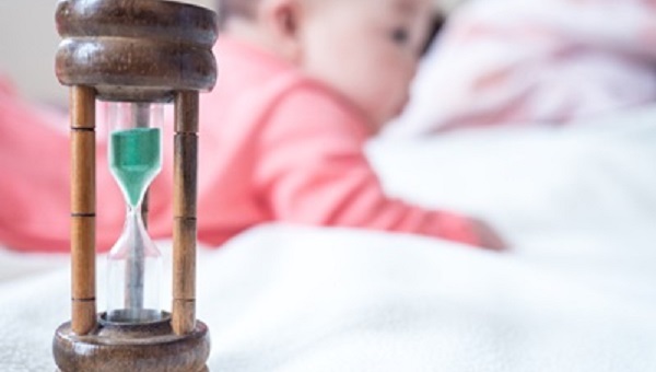 Baby and sand clock Concept of child growing and time spending for children or time of baby