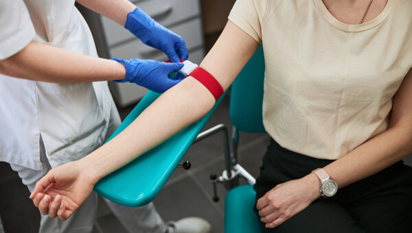 Woman in hospital chair preparing to have blood drawn